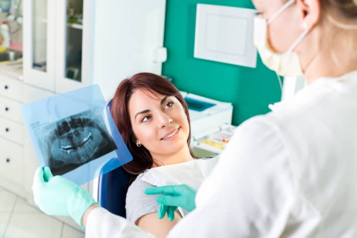 Dentist showing to the patient X-ray picture